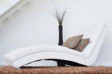 biały nowoczesny fotel na włochatym brązowym dywanie